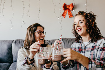 .A group of happy friends having a nice Christmas afternoon, drinking chocolate and eating Christmas cookies. Lifestyle photography