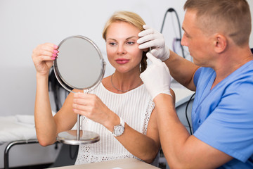 Man doctor is preparing female patient to procedure