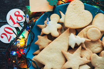 Plate with tasty holiday Gingerbread Cookies on wooden table. Merry Christmas and Happy New Year card 