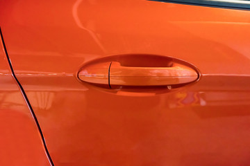 Orange car door handle. Car exterior detail