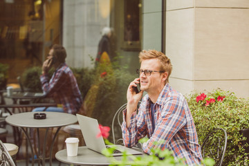 Handsome Man sitting in cafe and working on laptop