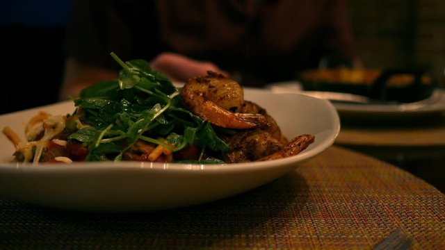 A tasty Shrimp and Pasta dish at a fancy restaurant sitting on table