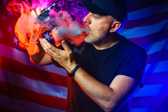 A man blows smoke from an electronic cigarette.