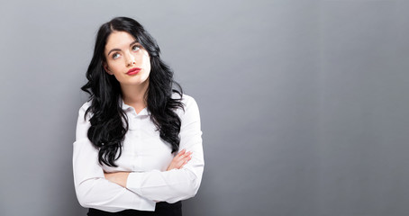 Young businesswoman in a thoughtful pose on a solid background