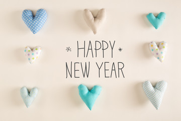 Happy New Year message with blue heart cushions on a white paper background