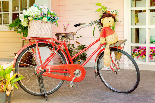 Vintage bicycle with doll and artificial flowers