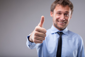 Smiling motivated man giving a thumbs up
