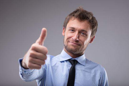 Happy successful man giving a thumbs up gesture