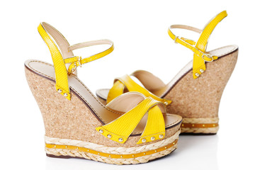 A pair of yellow high platform sandals isolated on white background.