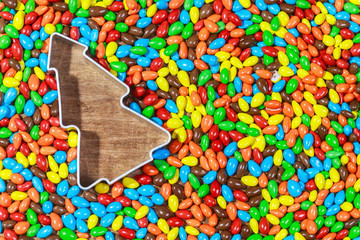 Christmas cookie metal mould on colorful background of candies