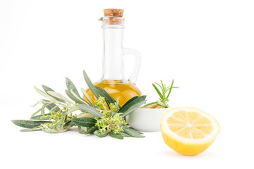 Glass bottle of premium virgin olive oil, lemon and some olives with olive branch isolated on a white background.