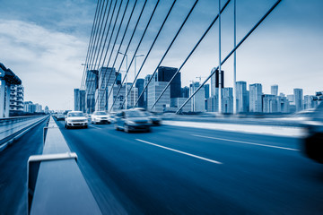 Fototapeta premium Traffic on modern bridge with skyline under blue sky