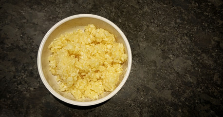 Small Bowl of Minced Garlic as Ingredient on a Stone Background