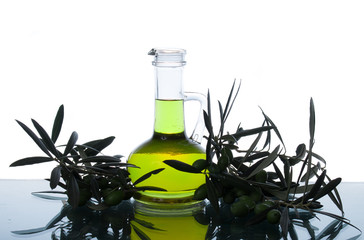 Glass bottle wtih extra virgin olive oil and olive branches. Olive tree brunch with olives isolated...