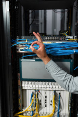 Close-up Of Engineers hand checking Server In Data Center