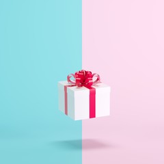 White gift box floating on blue and pink background. minimal christmas concept idea.