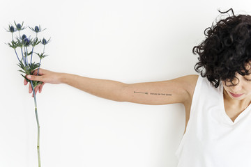 A woman is showing her tattoo on her arm