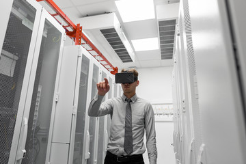  businessman in virtual reality headset over server room background