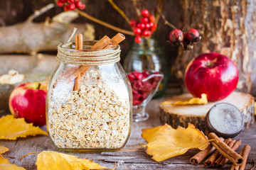 Dry oat flakes in a jar on a wooden table.