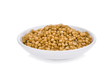 dried coriander seeds (Coriandrum sativum) in the white plate isolated on white background