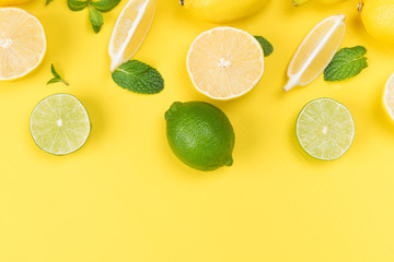 concept of lime and lemon with leaves on a yellow background of the board