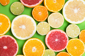 Fototapeta na wymiar colored background of different citrus round lobules, on a green table