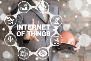 Internet Of Things. IOT Industry 4.0. Man with hard hat using virtual interface offers internet of things text icon.