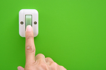 Hand turning on-off the light with wall switch