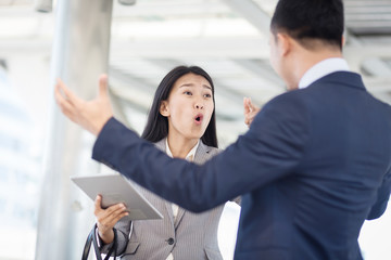 Young businesswoman holding papers talking with a businessman with anger, Boss found a mistake in documentation. Work failure concept.