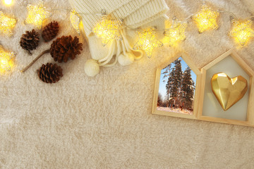 Winter concept with cozy lifestyle objects over fur carpet. Top view.