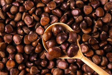 Roasted chestnuts on a wooden spoon.  Food background.