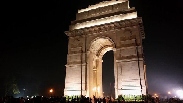 The iconic india gate in delhi shot at night with the silhouettes of families. This landmark designed by Sir Edwin Lutyens is a war memorial located on Rajpath. This is a favorite hangout for families