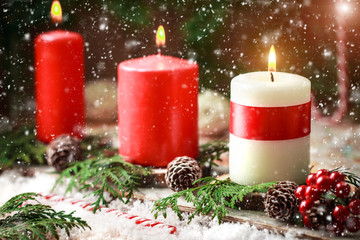 Christmas card with burning candles and decorations.