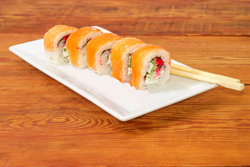 Sushi with salmon with chopsticks on rectangular dish