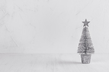 Silver christmas tree on white shabby plaster and wood board.