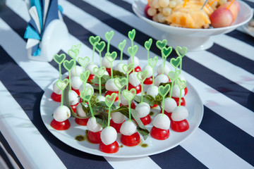 канапе с томатами и сыром на тарелке