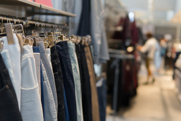 Pants and jeans on the racks in clothing store