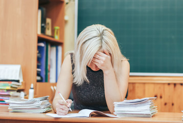 difficult work of the teacher. The teacher bowed his head over the control works of the students