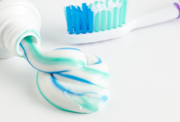 A tube of toothpaste and a toothbrush on white background