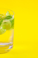 Glass with Water on Yellow Background