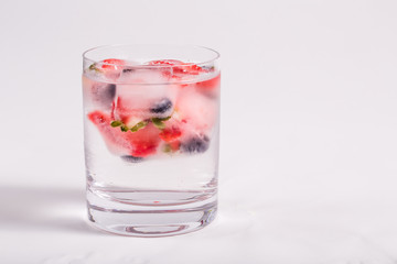Fototapeta na wymiar Ice berries in glass of water