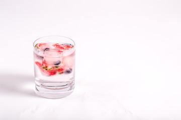 Ice berries in glass of water