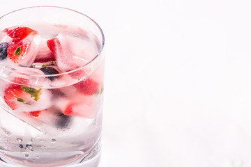 Ice berries in glass of water