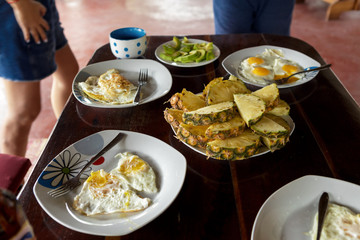 Breakfast table with fried eggs and fruits
