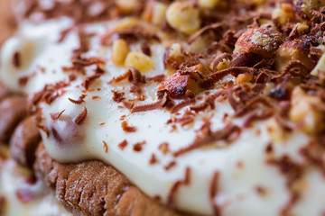 Homemade cake with nuts, cream and grated chocolate, macro. Sweets