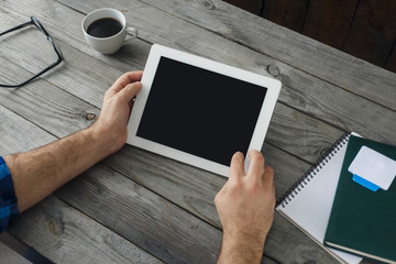 Fototapeta na wymiar Digital tablet in man hand close up. Home workplace