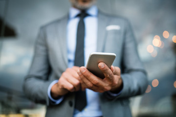 Businessman with smartphone in an outdoor hotel cafe.