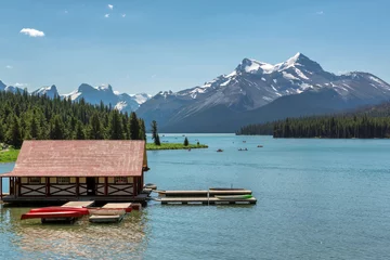 Papier Peint photo Lavable Parc naturel Beautiful Maligne Lake with a boathouse and canoes and snow covered mountains, Jasper, Canadian Rockies.