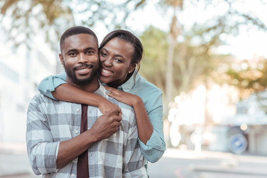 Content African couple standing together outside on a sunny day