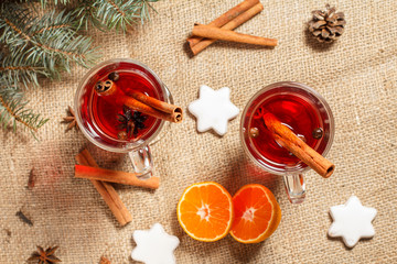 Glasses of Christmas mulled wine with spices and orange on sackcloth